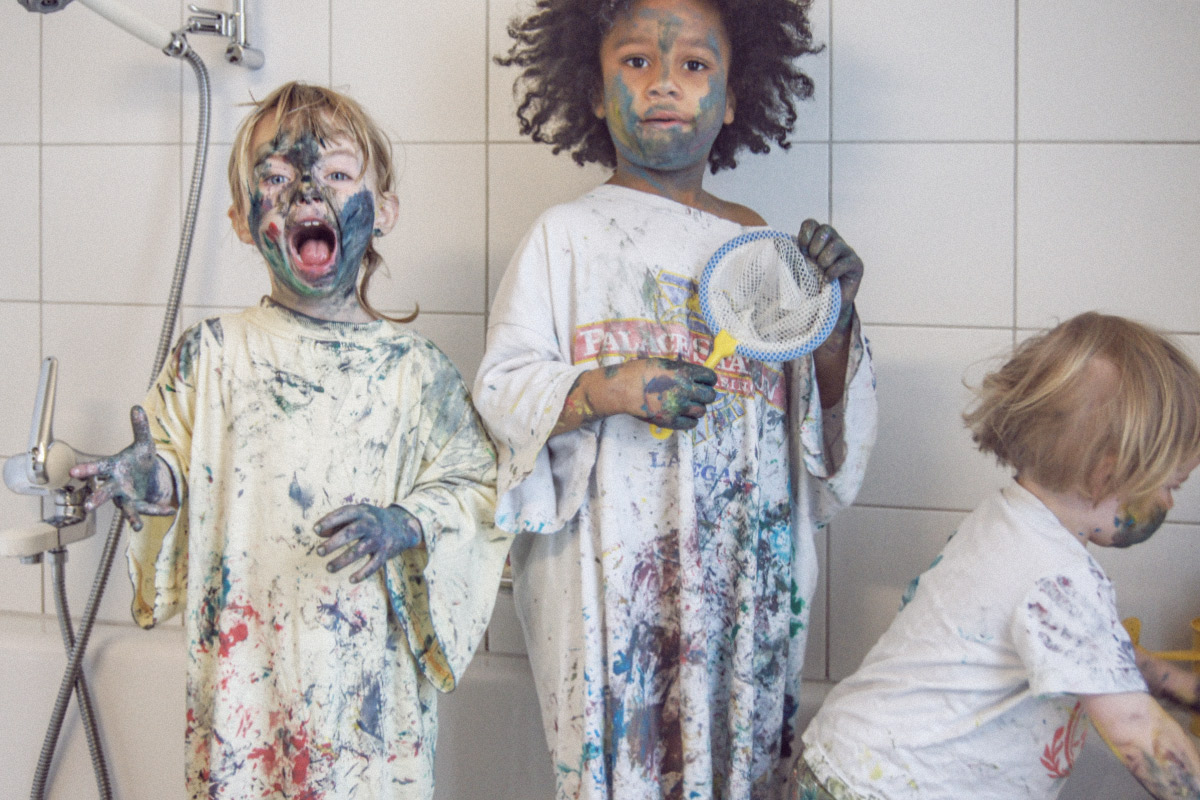 Malen mit Fingerfarbe. Die drei Mädels voll mit Fingerfarbe in der Badewanne.